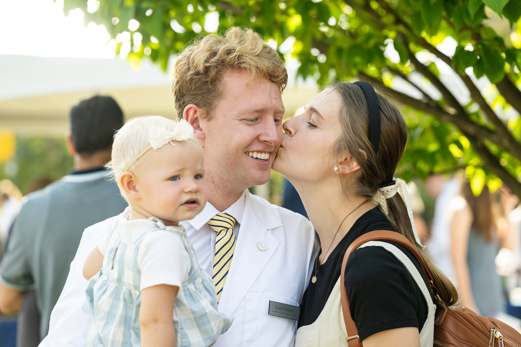 Austin Hansen gets a kiss from wife Eliza as he holds their daughter Maggie