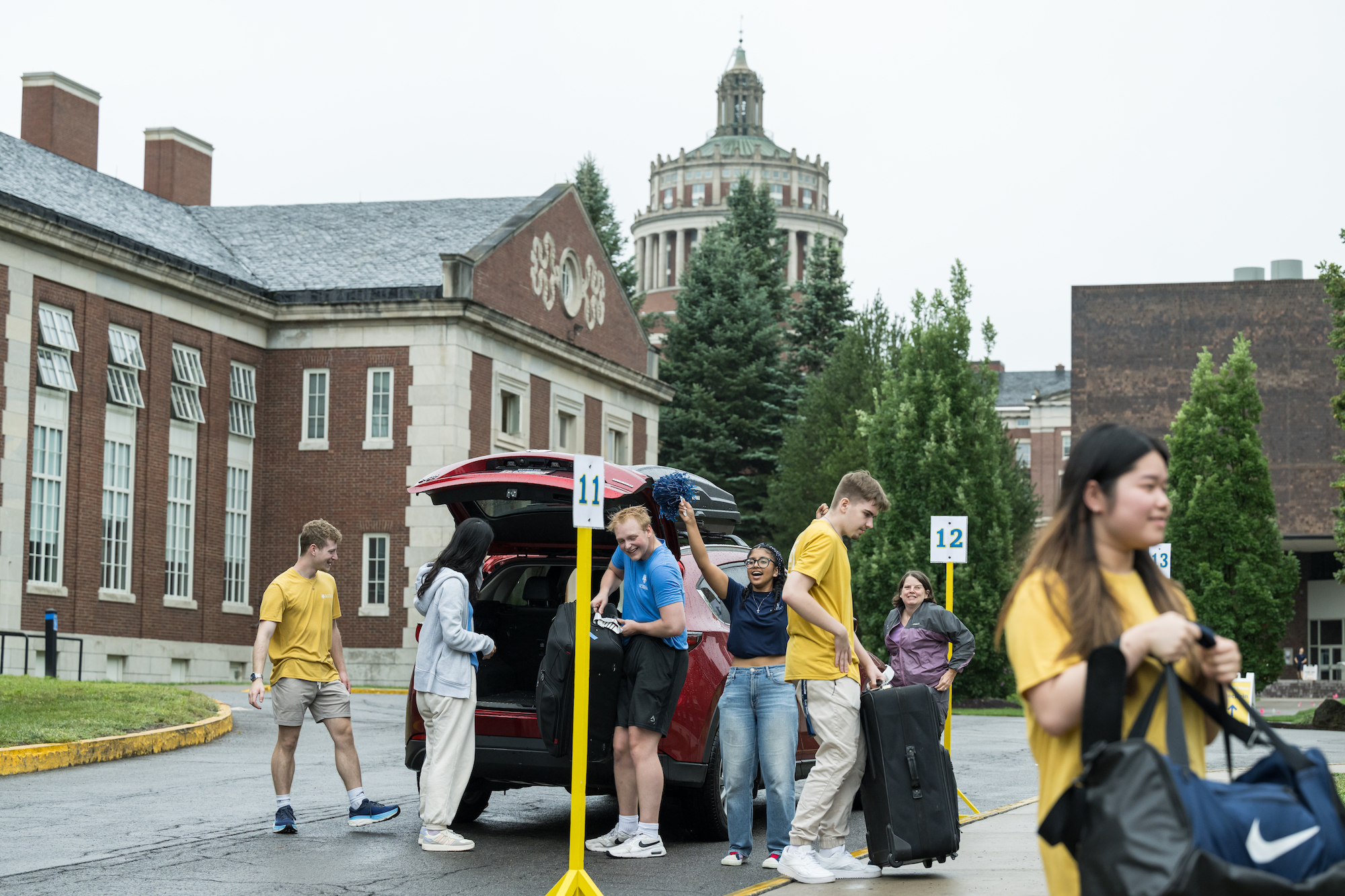 Rochester students help new students unpack cars in the parking lot