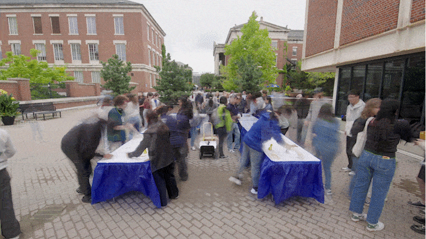 GIF of timelapse showing University of Rochester Class of 2028 students signing the class roll at tables set out on the Wilson Quadrangle. 