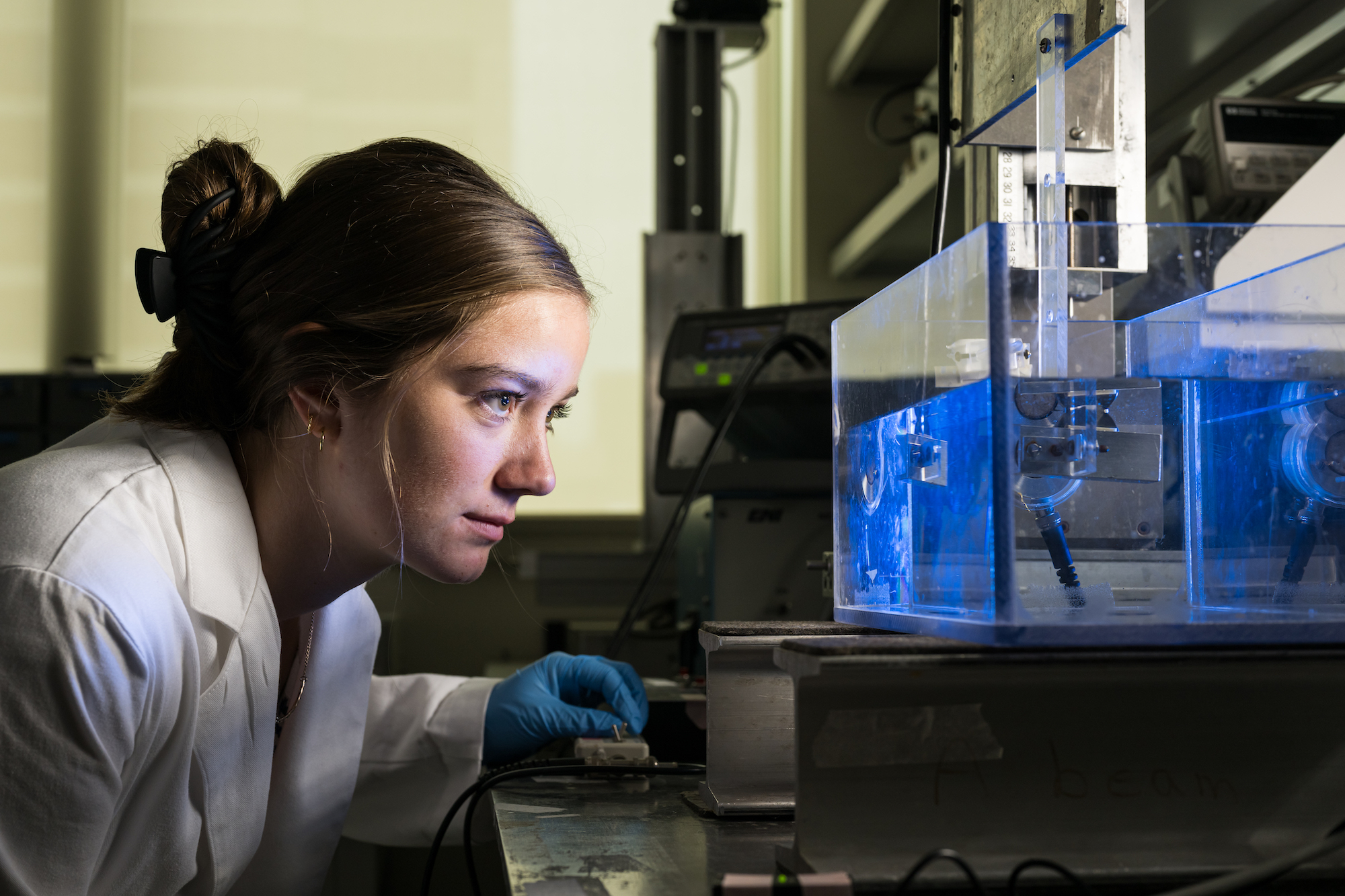 Scientist closely observes an apparatus in a lab