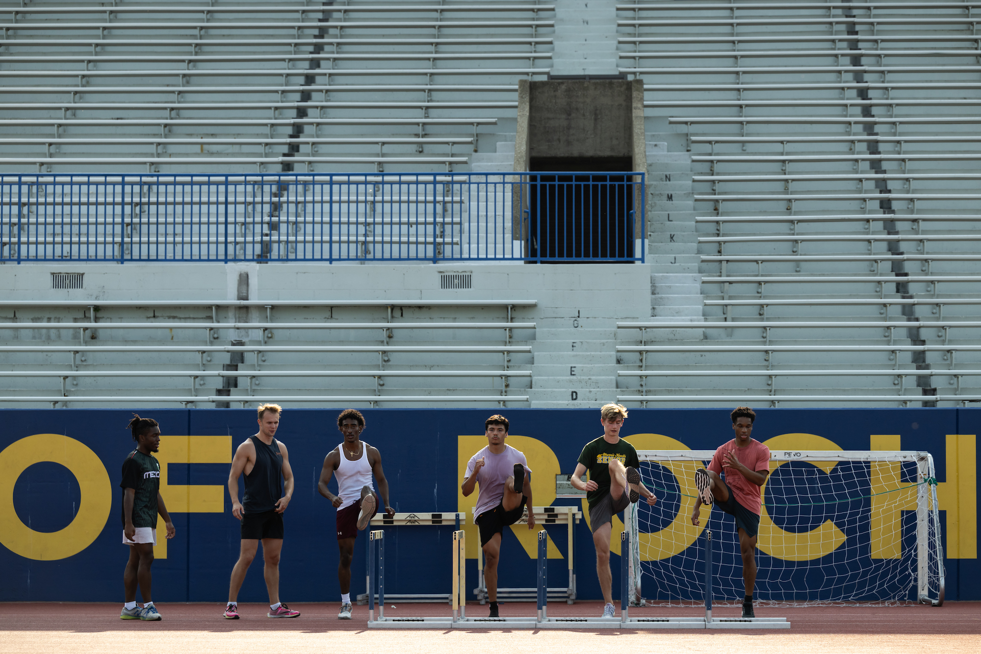 Men's track team members perform a drill 