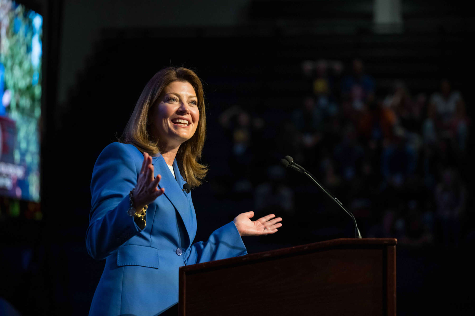Norah O'Donnell smiling while delivering a keynote address on stage.