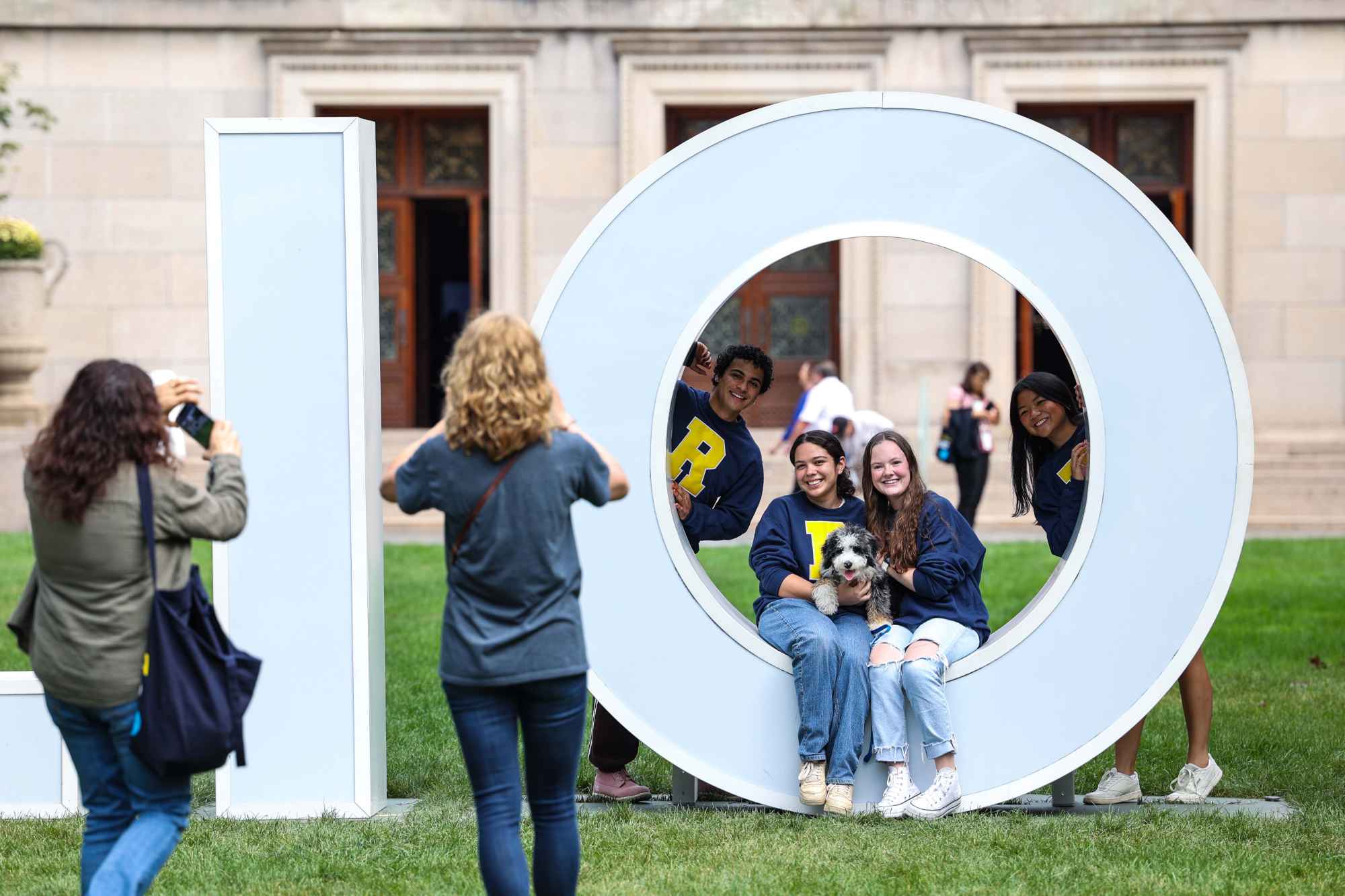 Students pose for a photo in a giant letter "O" on the Eastman Quad.