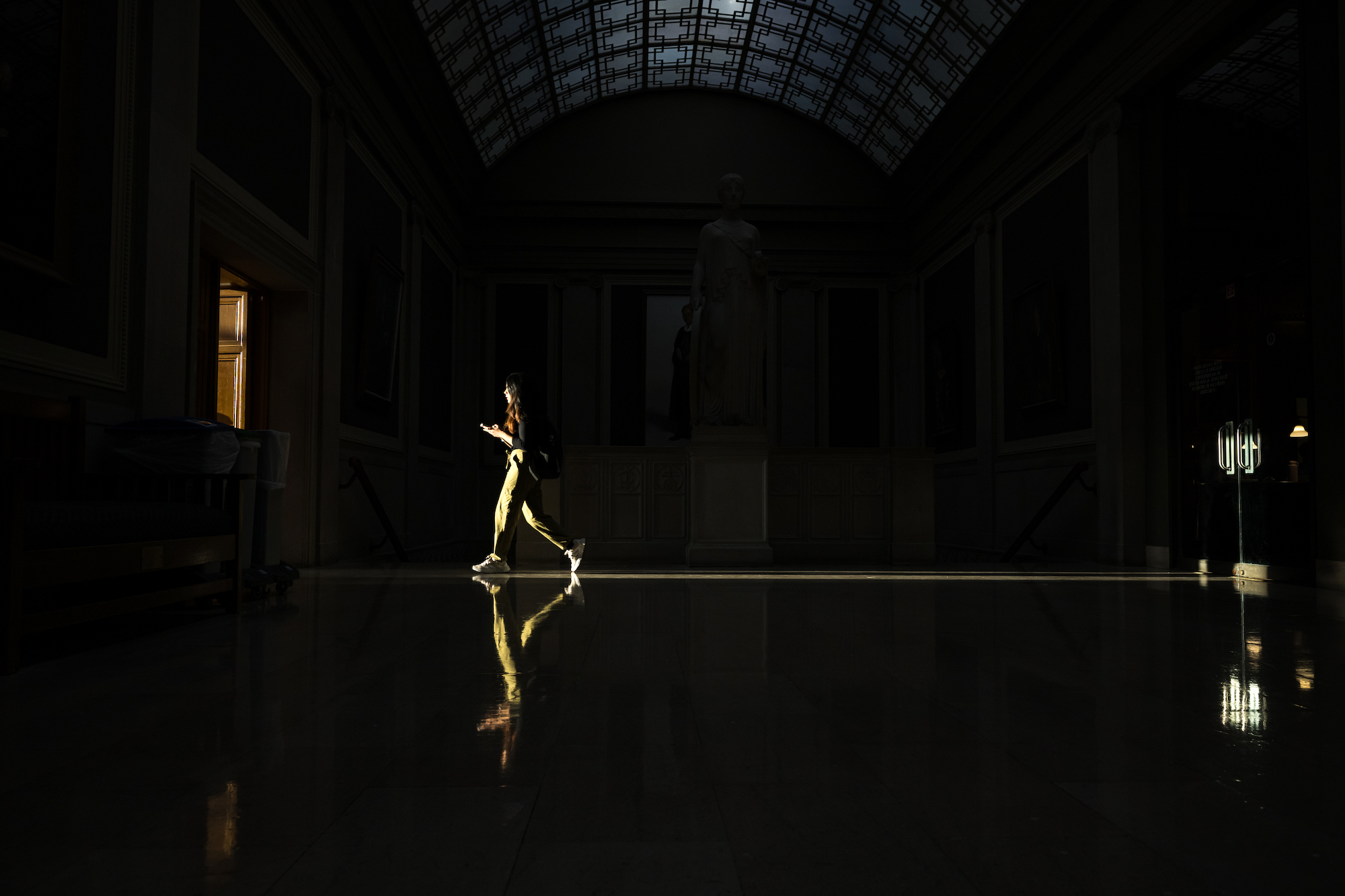 Evening sunlight shines through a doorway as a student walks across a room