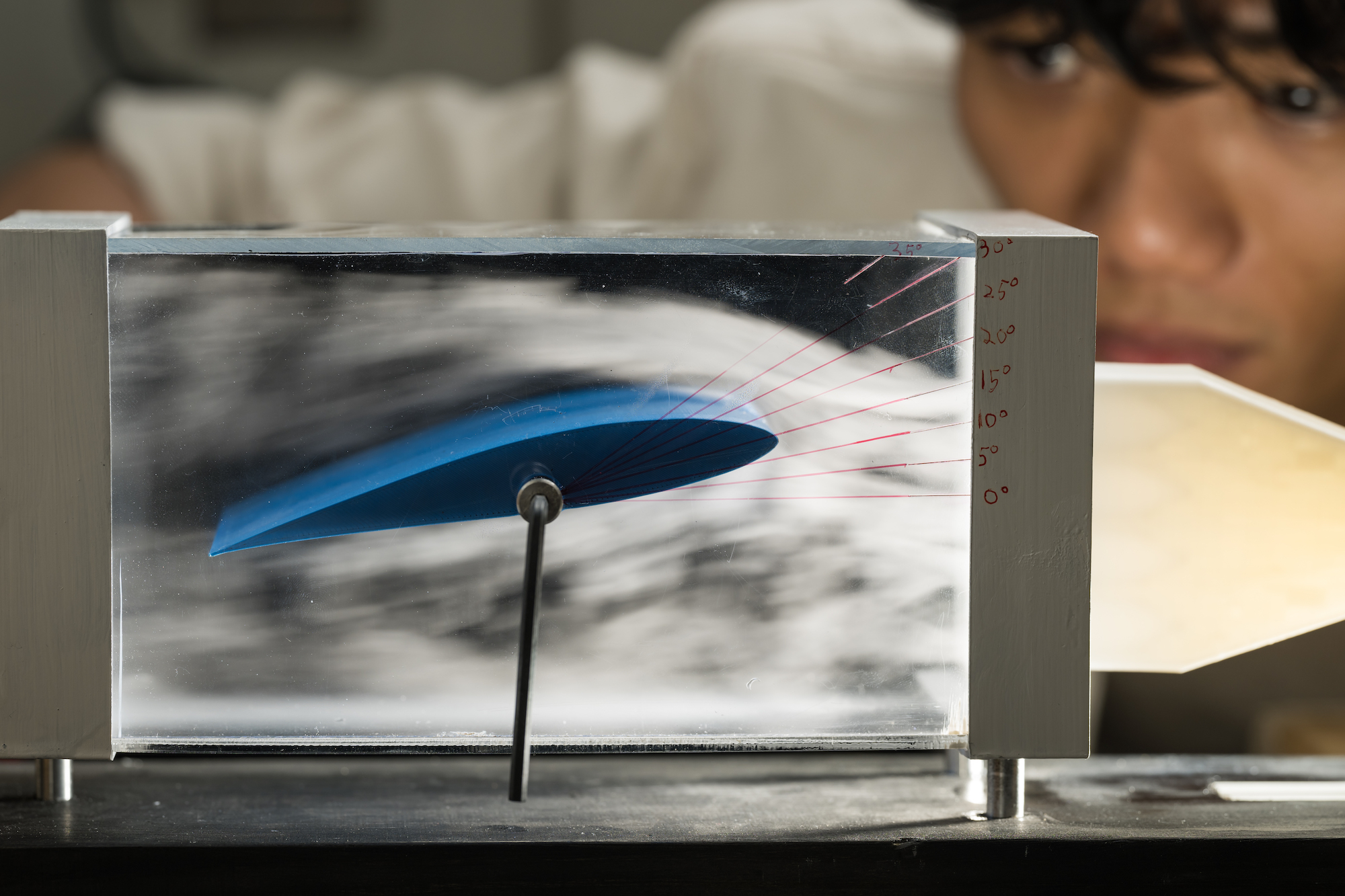 Elvis Imamura watches as machine smoke flows over an adjustable 3D-printed wing