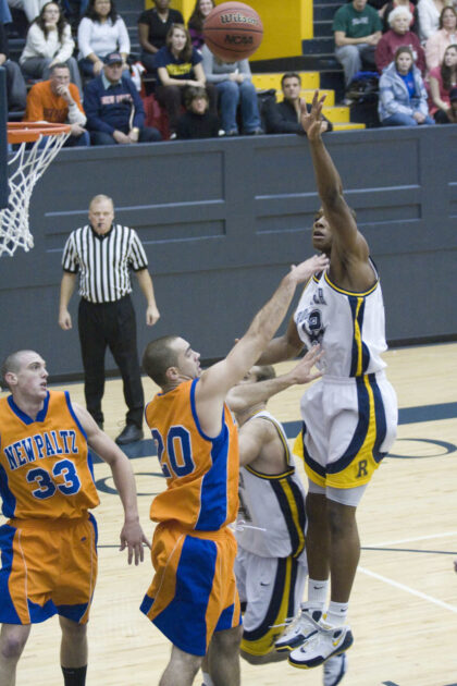 Jon Onyiriuka makes a hook shot during a University of Rochester college basketball game.