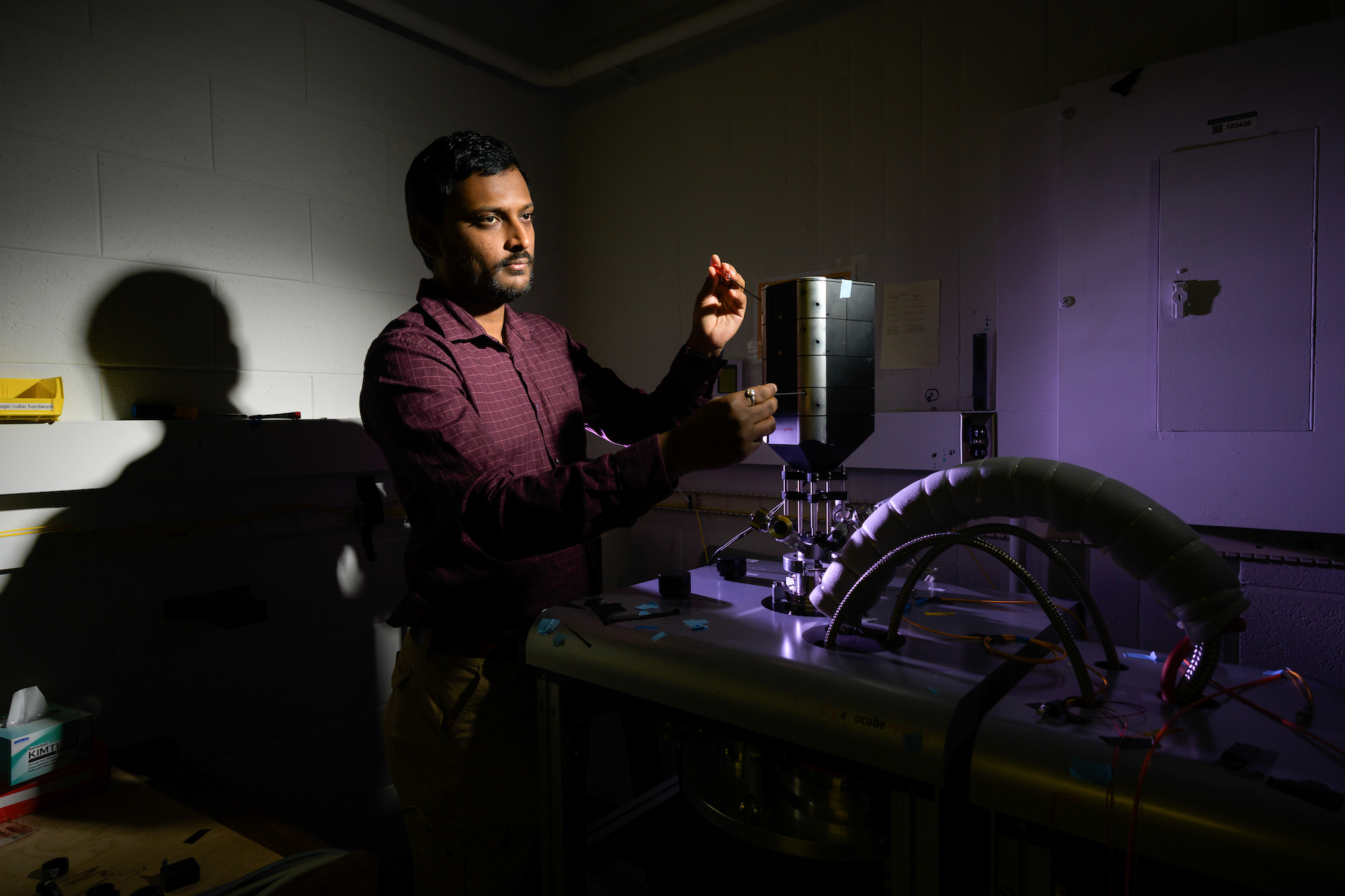 Optics PhD student Arnab Barnam Ray adjusts a confocal microscope. 