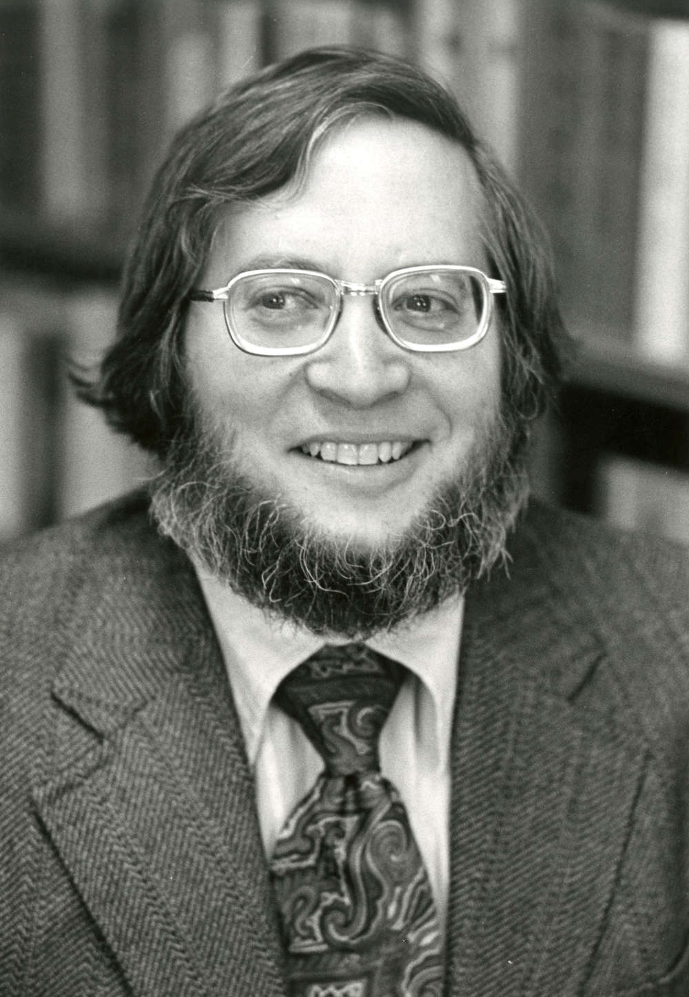 Black and white archival image of William Hauser smiling at the camera.