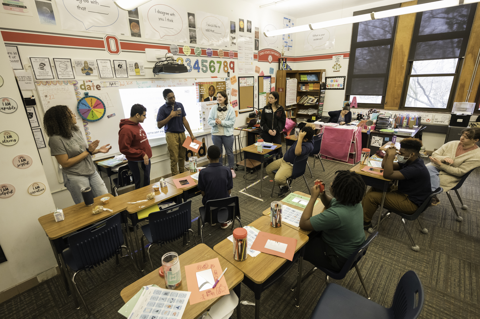 College student volunteers work with middle school students. 