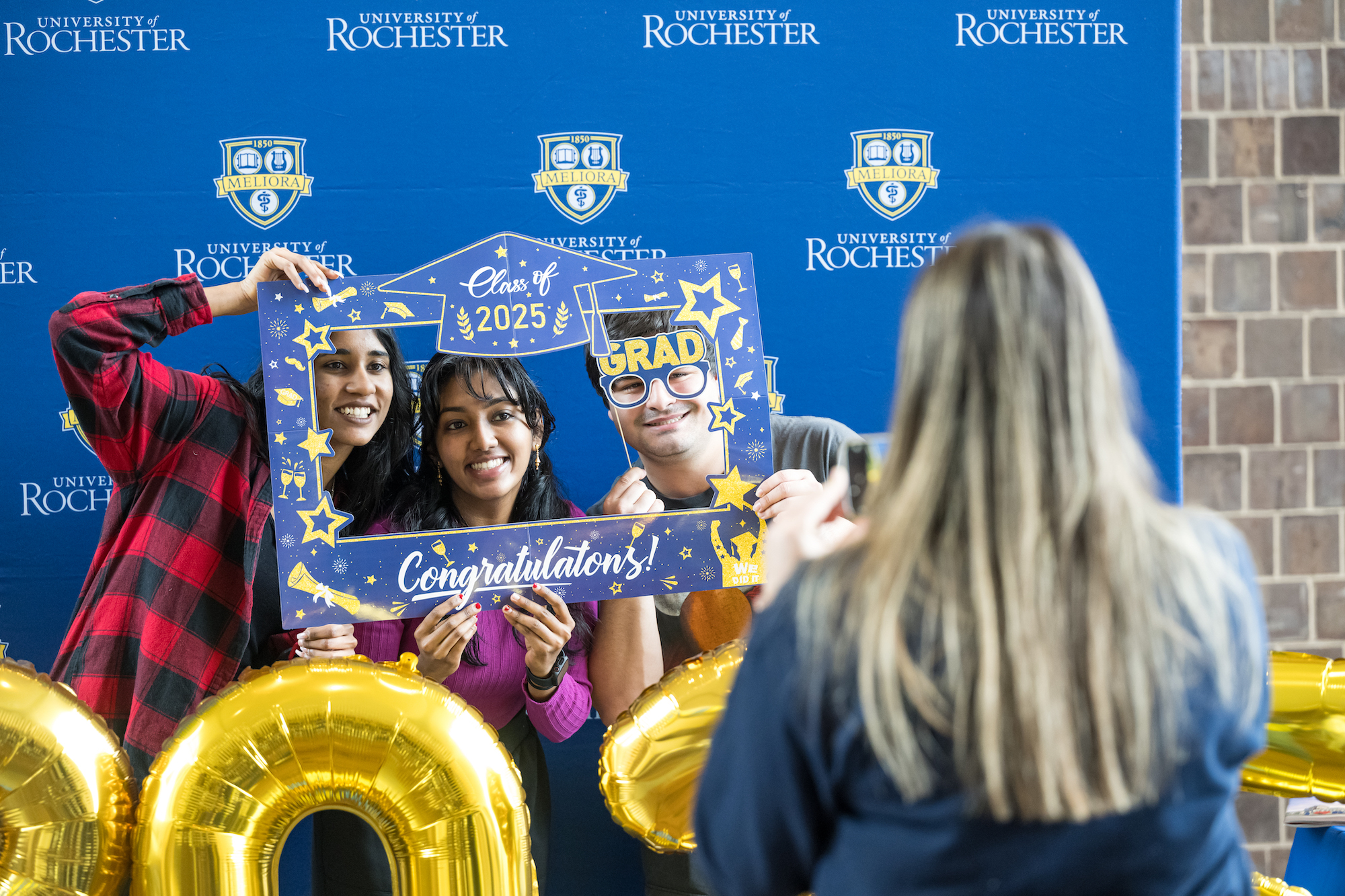 Class of 2025 students pose for a photo after picking up regalia. 