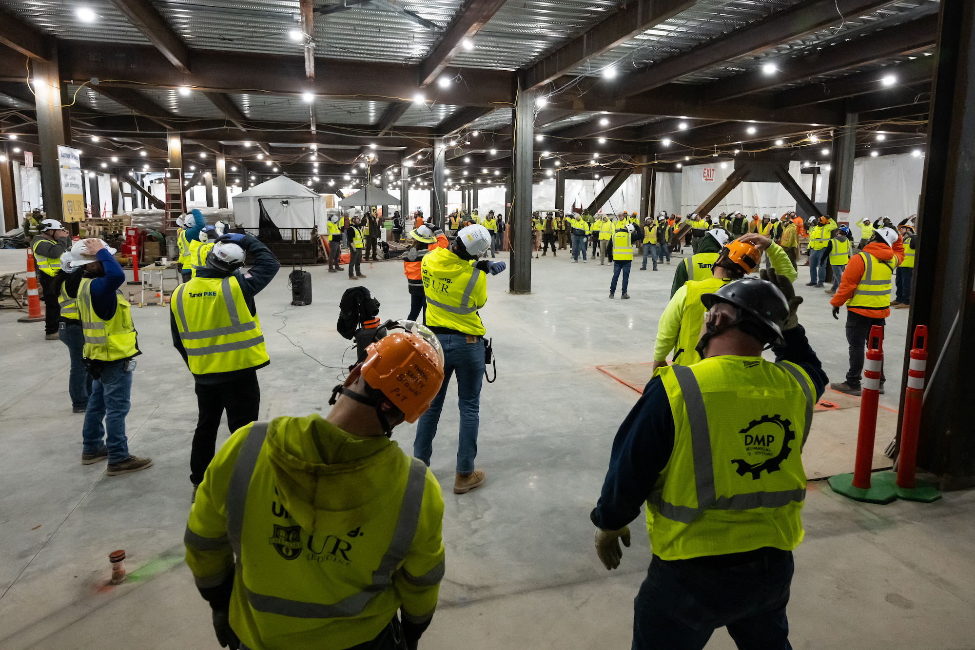 Construction workers Workers gather for a morning stretch and flex session.
