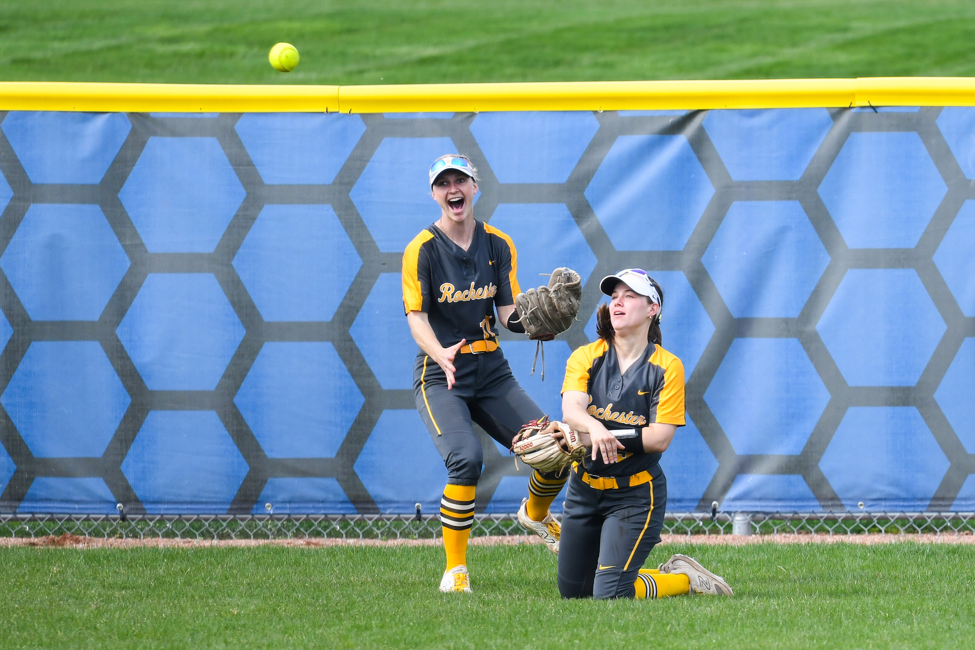 Sara Mazur throws to the infield as teammate Jensen Sminchak reacts. 