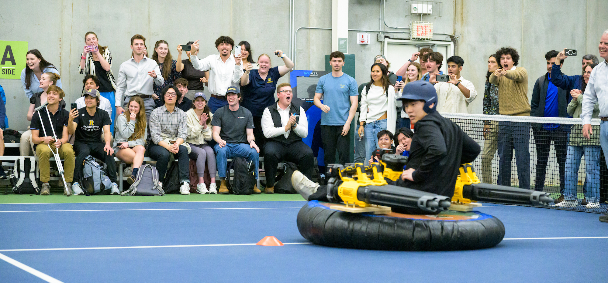 Attendees react as student Ian Yao from Team Alligator competes against Team Crocodile in hovercraft racing. 