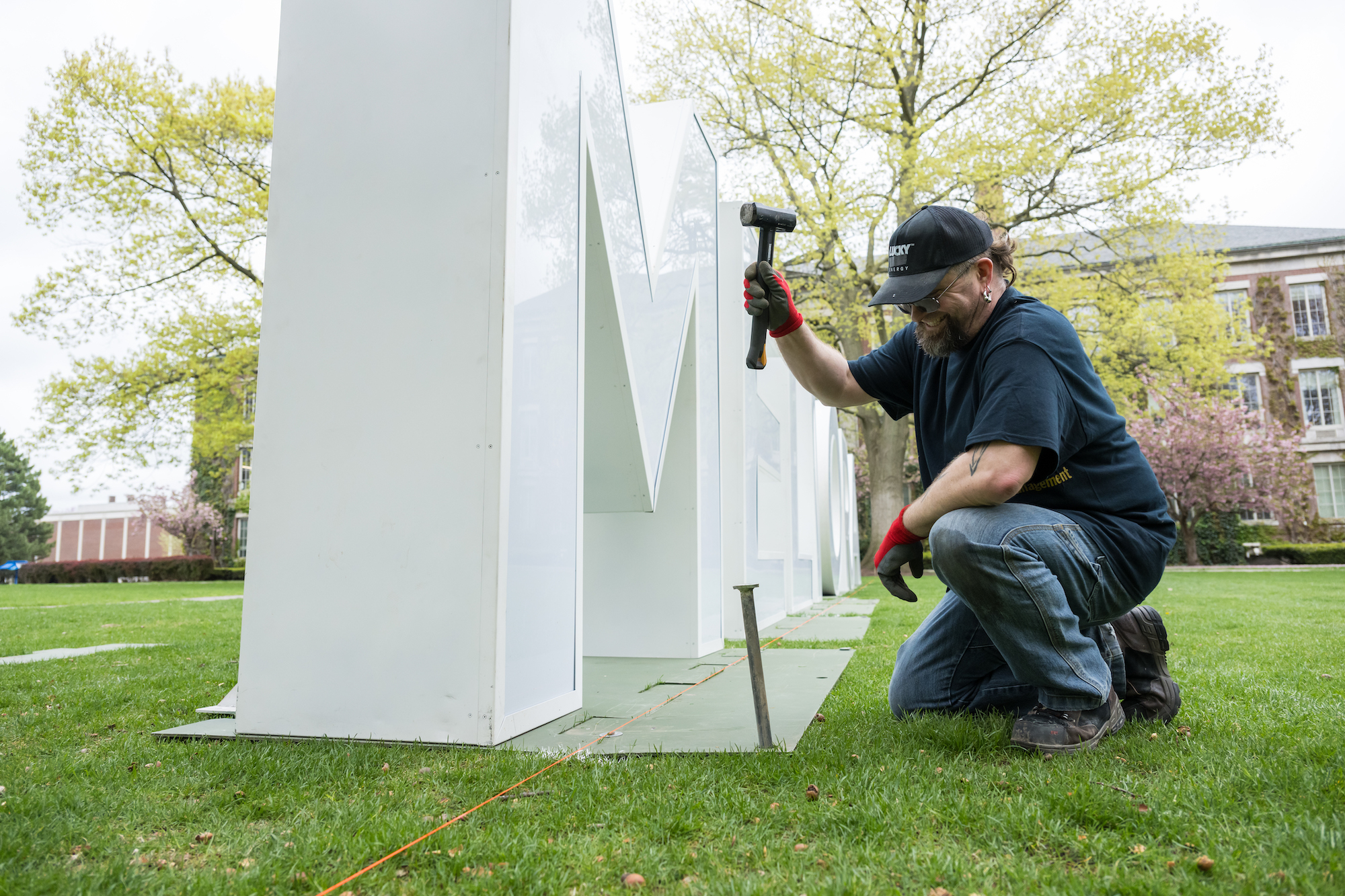 A staffer sets up large letters spelling out Meliora. 