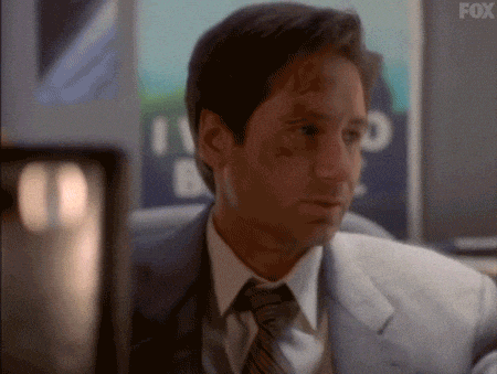 GIF of a frustrated Fox Mulder from the X-Files, who believes in government conspiracy theories, with an