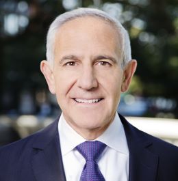 professional portrait of a man wearing a purple tie and dark jacket.