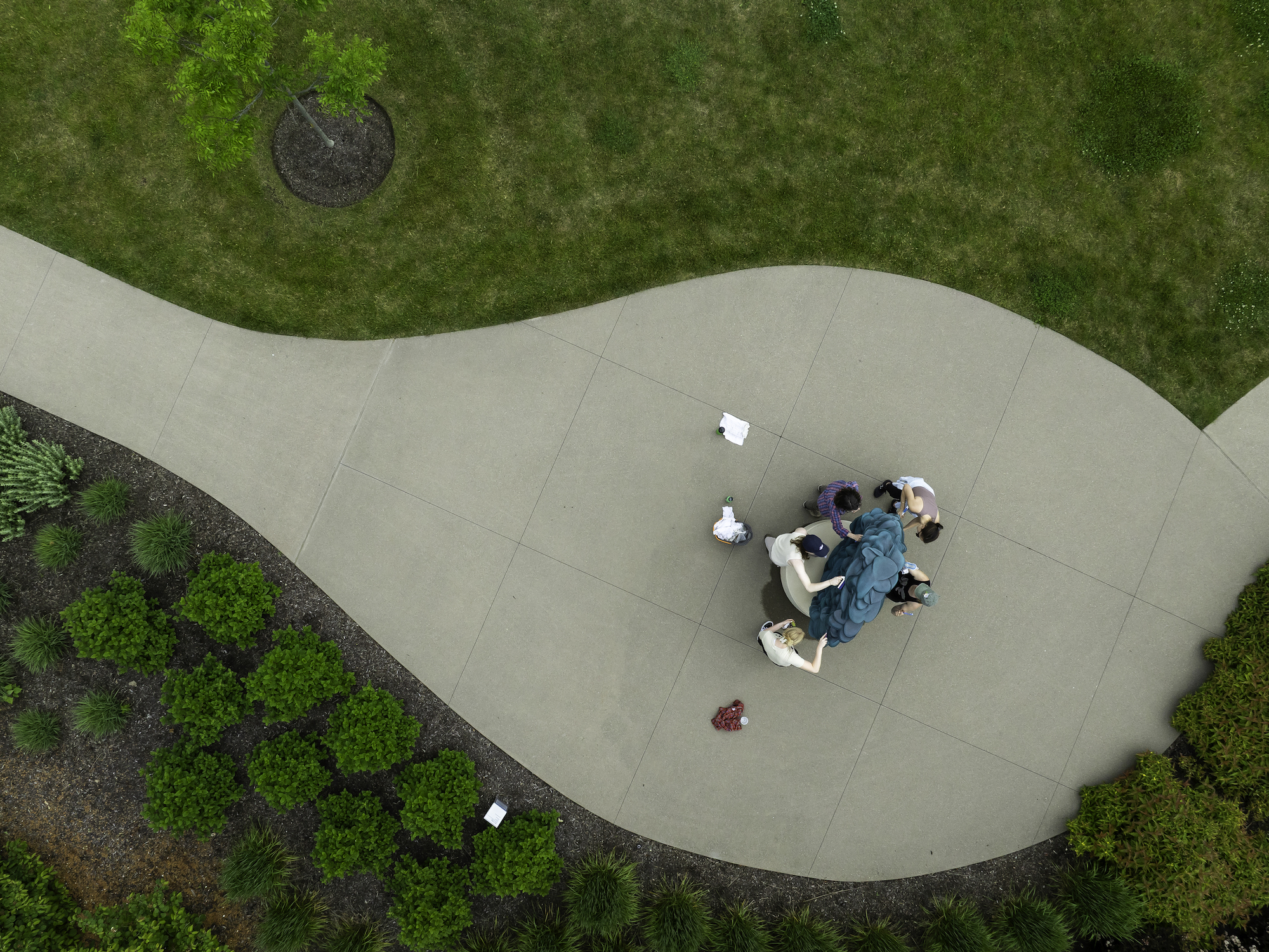 Aerial shot of a museum staff cleaning a bronze sculpture.