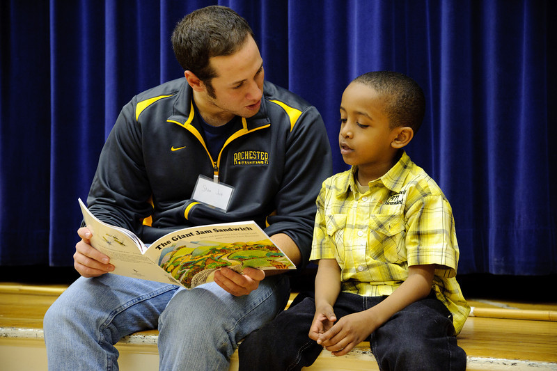college student reading to little boy