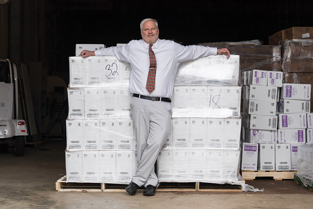 Don Libby, standing in front of a truck filled with boxes