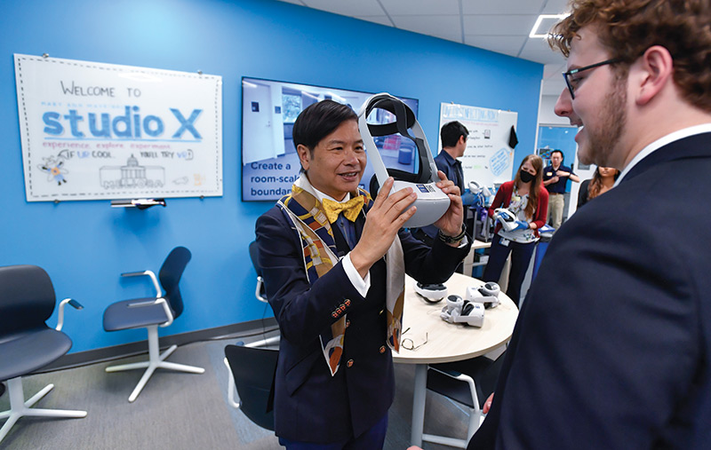 photo of University of Rochester alumnus and trustee Evans Lam preparing to put on a virtual reality headset