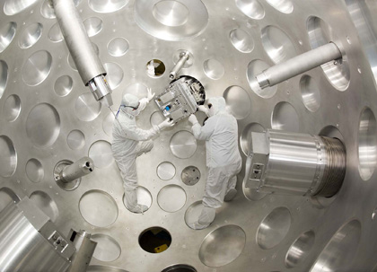 scientists in clean suits on a laser array