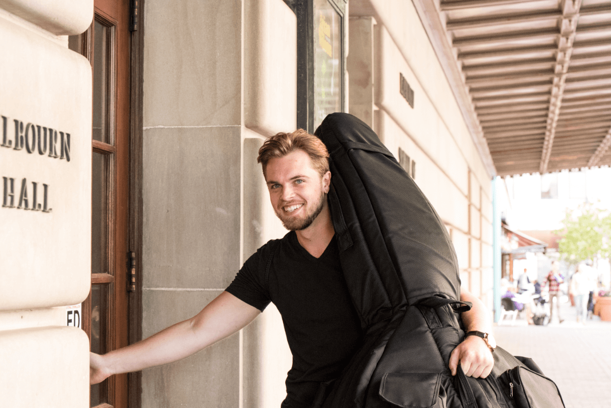 University of Rochester music student with instrument entering Eastman School of Music.