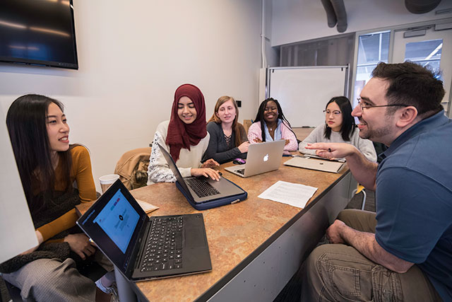 An instructor meeting with students.