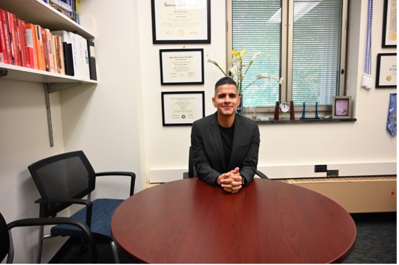 The director sitting at a table in their office.