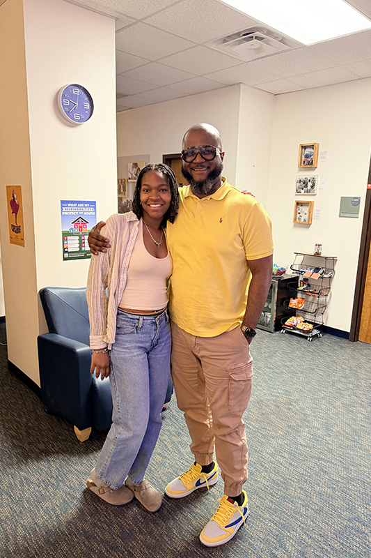 Two people pose for a photo while standing close together.
