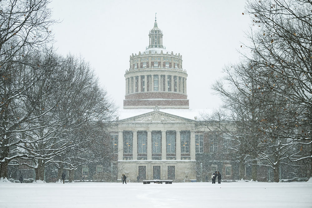 A snowy day on campus with Rush Rhees Library in the background.