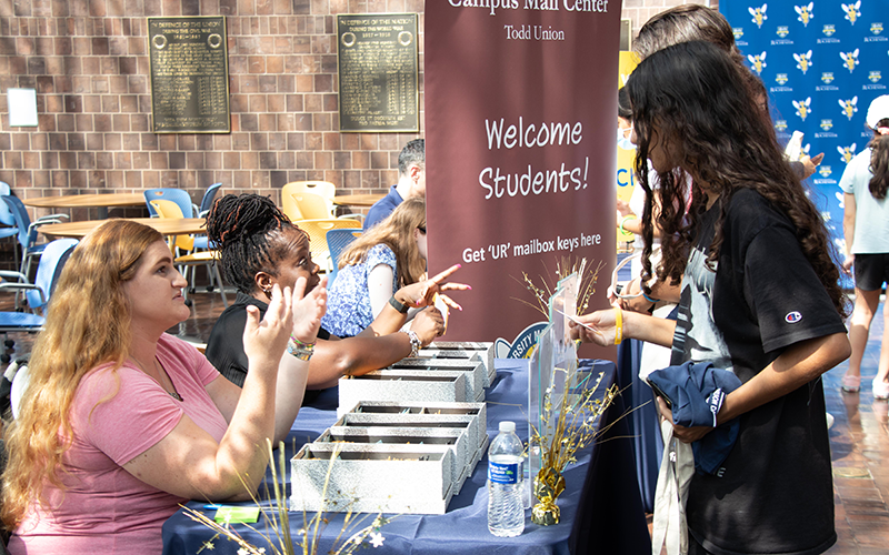 Photo of Campus Mail Center staff chatting with a student during Welcome Week Check-In