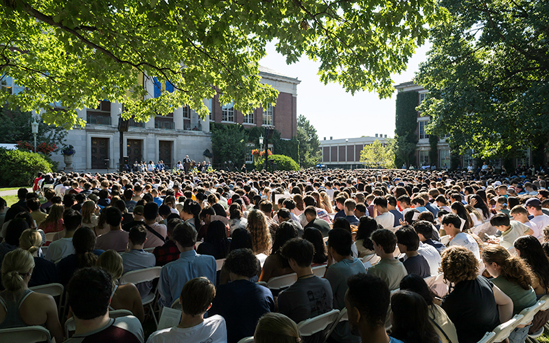 Students and families sit in chairs on Eastman Quad during the Convocation ceremony