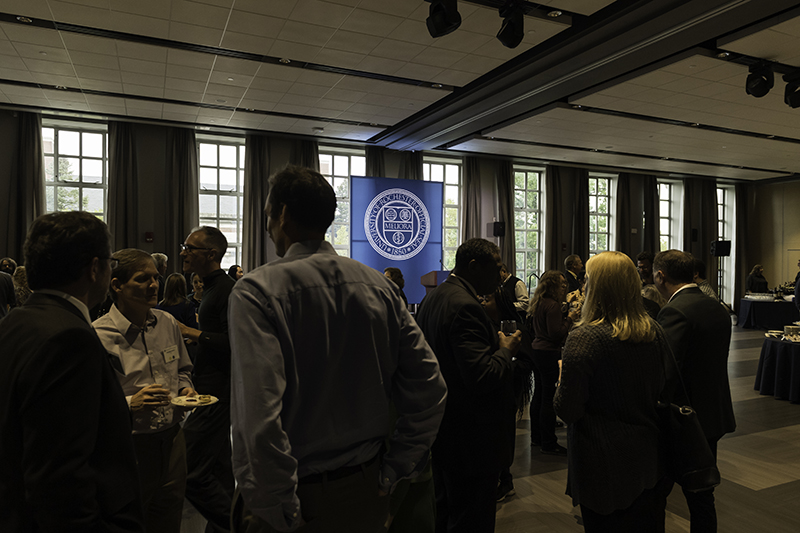 A group of people chatting in a large room.