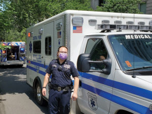 a volunteer emt named timmy li standing in front of ambulance