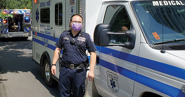 a volunteer emt named timmy li standing in front of ambulance