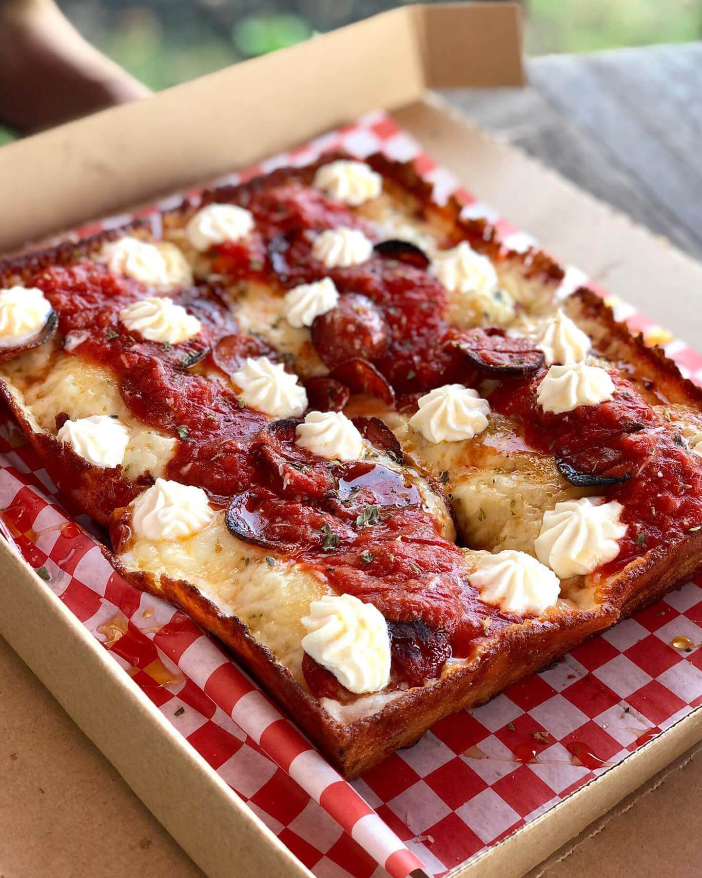 An image of a Sicilian slice of pizza with pepperoni slices on top