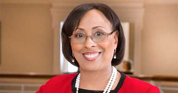 Kathy Waller ’80, ’83S (MBA) in a red suit jacket