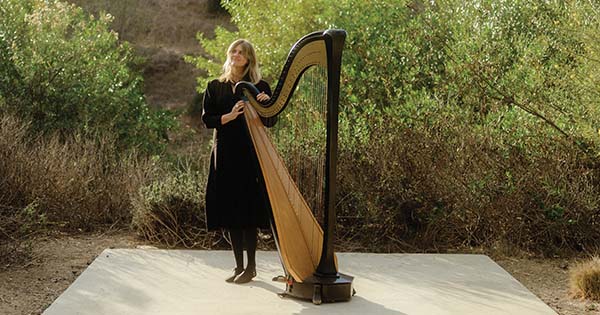 Mary Lattimore ’02E standing with Harp