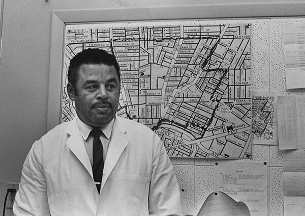 page18_inreview_ATA_Woodward-600x424 black and white photo of physician Kenneth Woodward as he stands in front of a board while in his white coat