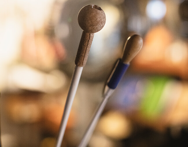 two batons pictured with the bton on the right which contains a rubber pen grip attached to it