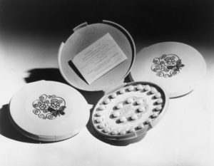 black and white photo of birth control in clamshell packaging with flowers and butterfly on the front of the case