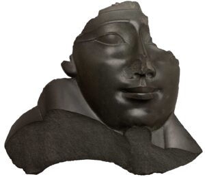 28_37.1516E_edited_PS9 Face and Shoulder from an Anthropoid Sarcophagus, 332–30 B.C.E. Black basalt, 18 1/2 x 20 1/2 x 5 in. (47 x 52.1 x 12.7 cm). Brooklyn Museum; Charles Edwin Wilbour Fund, 37.1516E