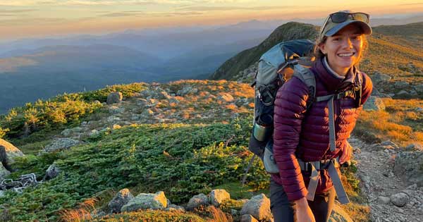 Marcelina wearing hiking gear, pictured at the summit of a cliff