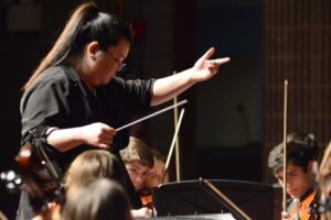 Tanya Chanphanitpornkit conducting an orchestra