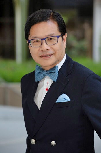 Evans Lam ’83, ’84S (MBA) in a blue suit and blue bow tie