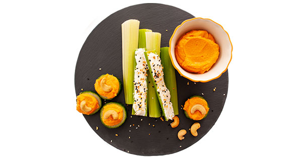 A plate of food on a black dish called ants on a log 2.0 and cucumber circles