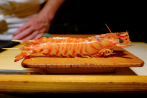 A raw shrimp on a wooden cutting board