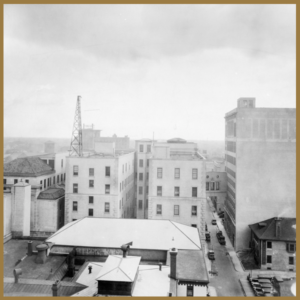 black and white photo of skyline, with radio tower in background