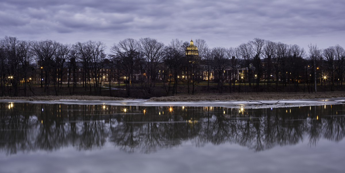 Image of campus along river at dusk
