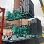 generators being lifted onto roof of building with a crane